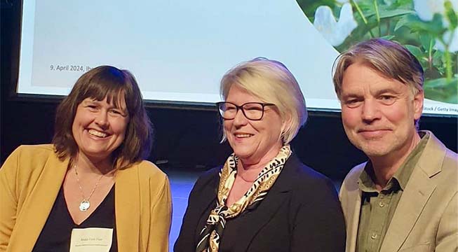 Tre blide menneske sit tett saman