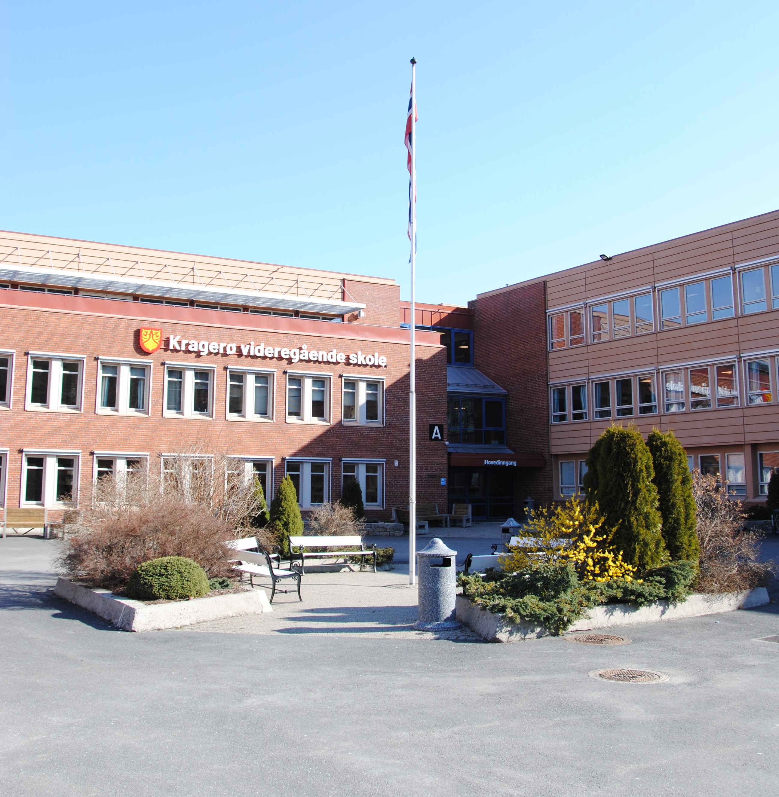 Bilde av skolens inngangsparti og skolegården.