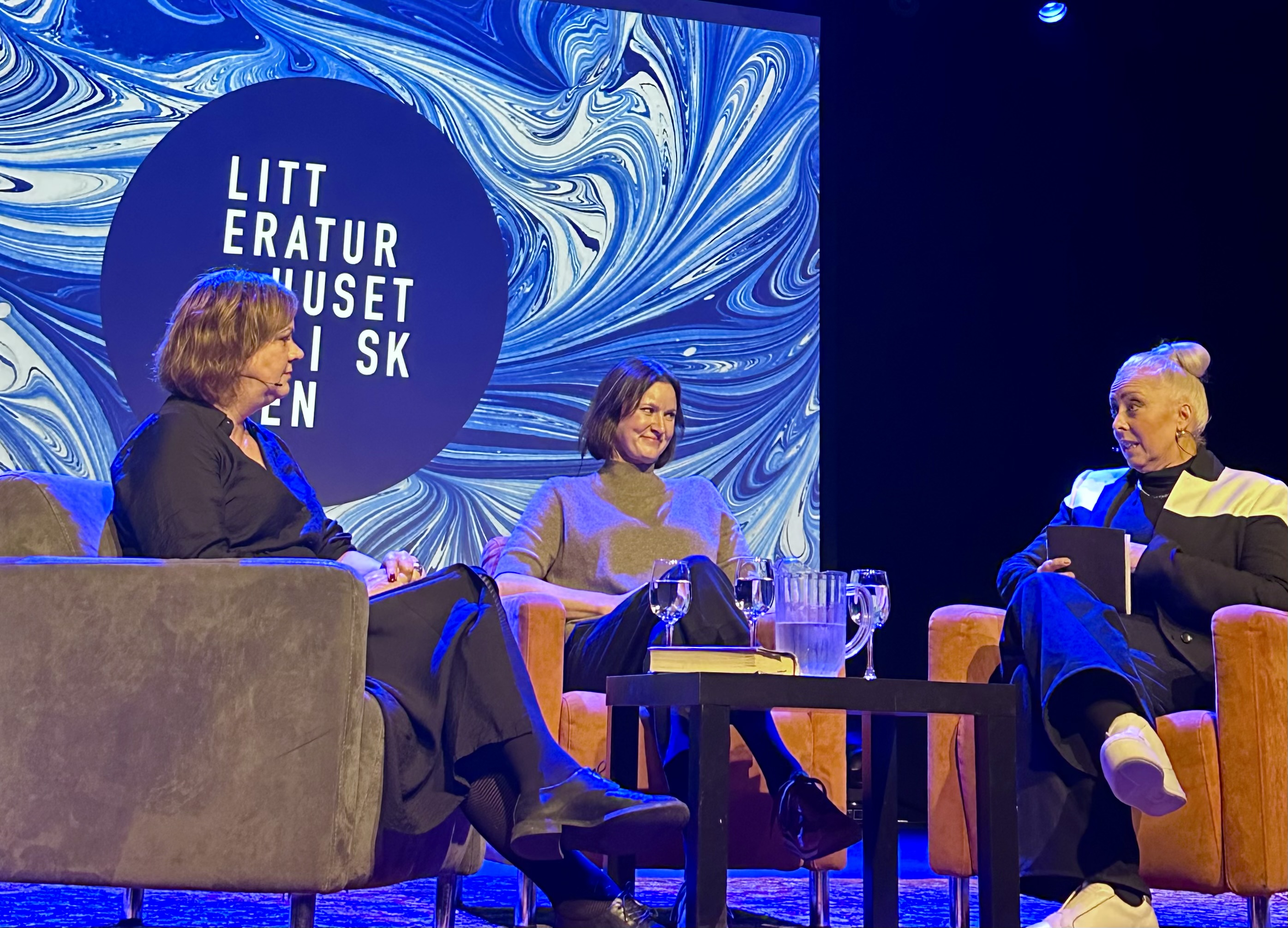 Tre damer sitter på en scene. Det er bokbad på Litteraturhuset i Skien.