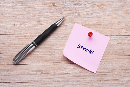 Penn og et notatskriv med ordet "streik" på