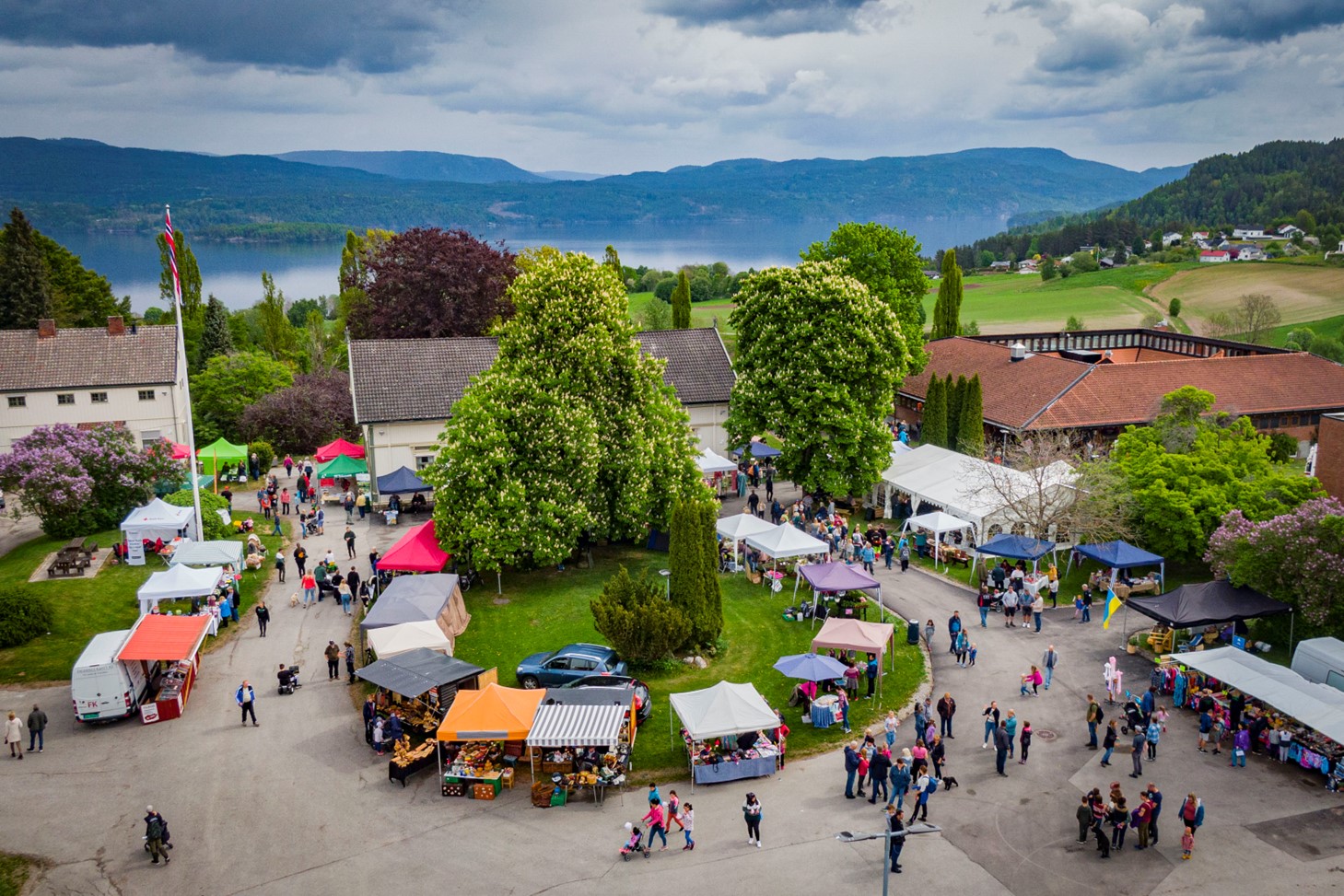 Oversiktsbilde over markedsplassen på Minidyrskuen fra tidligere arrangement. Folk og utstillingsboder.