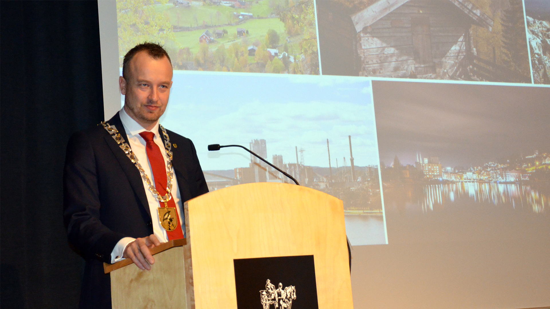 Mann med ordførerkjedet til Telemark står ved en talerstol