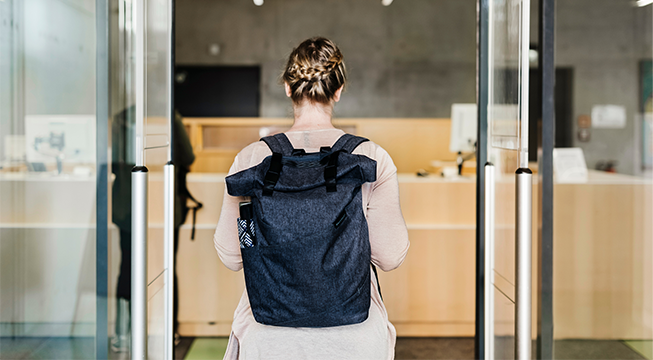 Kvinne som går inne en glassdør som er åpen