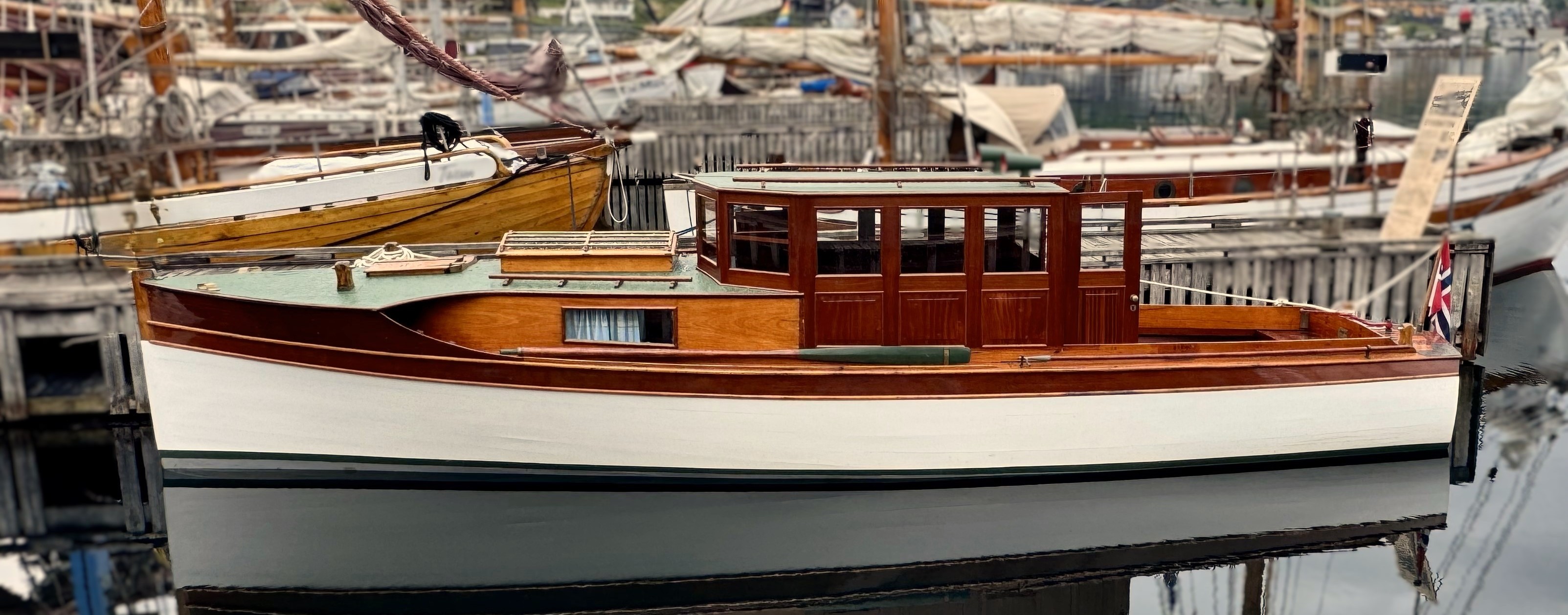 Eldre trebåt som ligger til kai