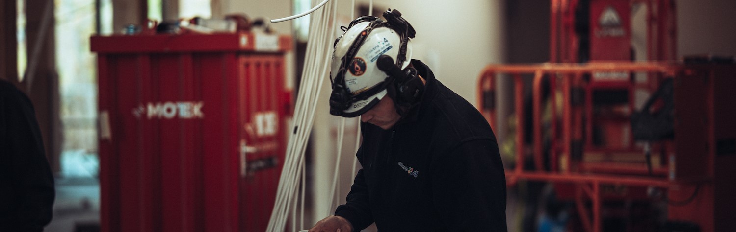 Mann med hjelm arbeider i industrien.