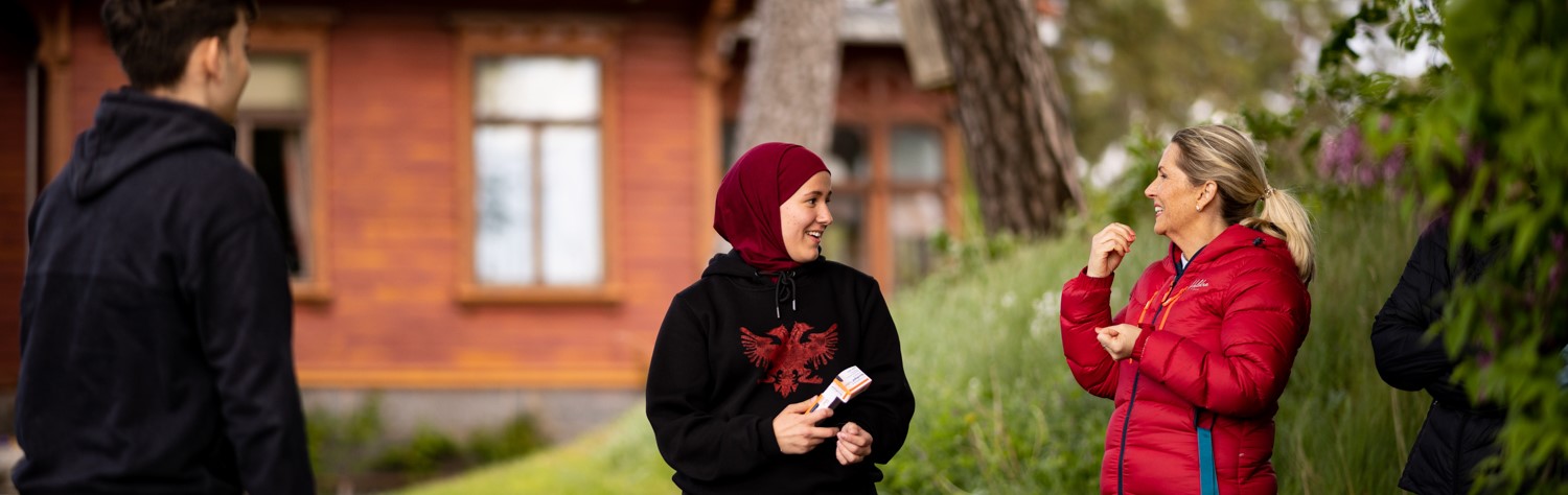 Bilde av tre personer som snakker og har det hyggelig.